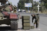 Ukrajinský technik nakládá munici do tanku na kontrolním stanovišti u města Mariupol