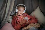 Dívka sleduje sociální sítě na telefonu
