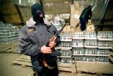 Příslušník zvláštní jednotky ruské policie hlídkuje u nelegálně vyrobené vodky (snímek z roku 1998)