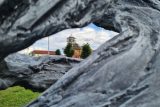 Kostel v Moravské Nové Vsi pohledem od plastiky, která připomíná tornádo.