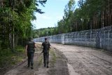 Litevští pohraničníci hlídkují u plotu na litevsko-běloruských hranicích