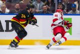 Útočník Vancouveru Canucks Pius Suter (24) během druhé třetiny v Rogers Aréně podrazil útočníka Caroliny Hurricanes Martina Nečase (88)