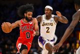 Coby White z Chicaga Bulls v běžecké souboji s Jaredem Vanderbiltem