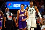 Devin Booker z Phoenixu Suns v přerušené hře s Janisem Adetokunbem z Milwaukee Bucks