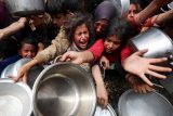 Palestinci čekající na jídli z charitativní kuchyně na snímku z dubna 2025