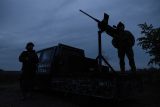 Členové mobilní dobrovolnické jednotky protivzdušné obrany stojí u svého kulometu během útoku ruských dronů v Kyjevské oblasti