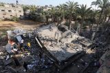 Palestinci si prohlížejí škody na místě izraelského útoku na dům v centrální části pásma Gazy