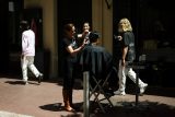 Kadeřnice v Cannes pracující na ulici kvůli rozsáhlému výpadku proudu (24. května 2025)