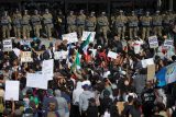 Demonstranti před budovou v Los Angeles, v níž sídlí řada federálních úřadů, nesli transparenty jako: „Stojím za všemi migranty“. Vchod střežili policisté a příslušníci Národní gardy