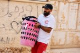 Paramedik pomáhá Palestincům přenášet osobní věci během izraelské vojenské operace nedaleko uprchlického tábora Jenin na Izraelem okupovaném Západním břehu Jordánu (8. července 2025)