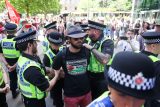 Policisté zadržují na náměstí Svatého Petra v Manchesteru demonstranta během protestu požadujícího zrušení zákazu činnosti skupiny Palestine Action