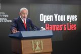 Izraelský premiér Benjamin Netanjahu na tiskové konferenci pro zahraniční novináře, na které v pozadí svítí nápis „otevřete oči před lžemi Hamásu“
