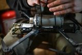 Ukrajinský voják připevňuje výbušné zařízení na útočný dron v rámci přípravy na výpad v Kosťantynivce