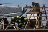 Polští hasiči opravují střechu domu v obci Wyryki, která byla poničena při snaze zneškodnit ruské drony