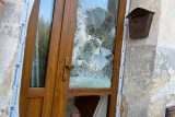 Rozbité dveře domu, ve kterém policie zadržela Tomáše Jiřikovského