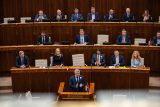 Národní rada Slovenské republiky. V první řadě za řečnickým pultíkem sedí členové vlády, za nimi uprostřed předsedající schůze a vedle něj místopředsedové parlamentu a v horní řadě poté předsedové parlamentních výborů