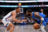 Basketbalista Aaron Wiggins z Oklahomy brání Kyrieho Irvinga z Dallasu