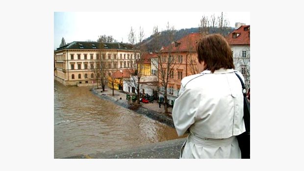 Žena sleduje stoupající Vltavu