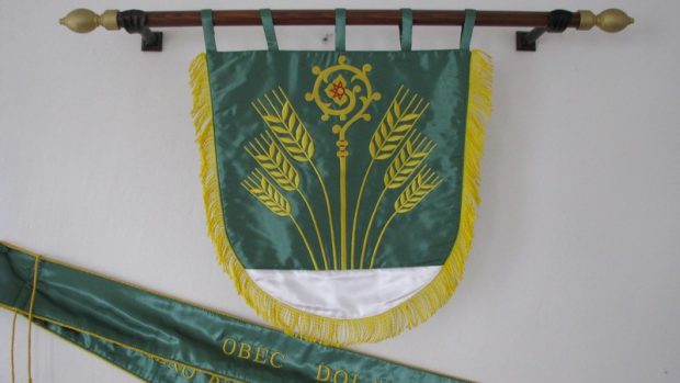 Obecní znak nese symbol úrodnosti kraje, berla symbolizuje historickou příslušnost k opatovickému klášteru