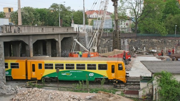 Vlak projíždí staveništěm u pražského Prašného mostu