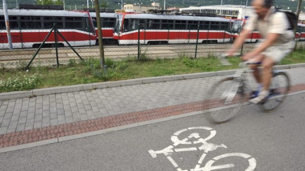 Cyklista v Brně míjí tramvaje odstavené ve vozovně