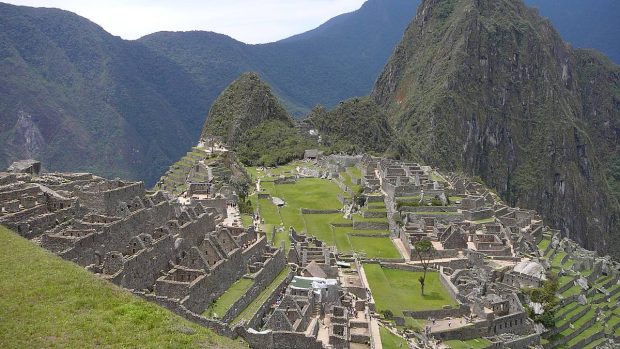 Machu Picchu (kečujsky Stará hora) s branou na inckou stezku za zády, uprostřed posvátné místo, v pozadí Wayna Picchu (kečujsky Mladá hora)