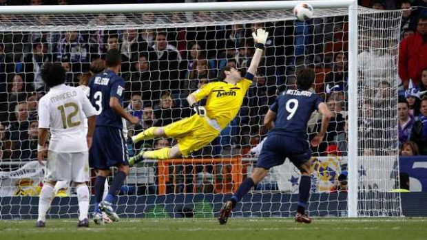 Real Madrid&#039;s goalkeeper Iker Casillas (C) tries to stop a goal scored by Malaga&#039;s Santiago Cazorla (unseen) during their Spanish First Division soccer match