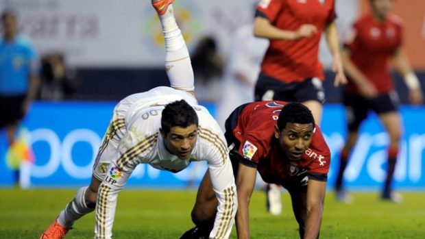 Osasuna&#039;s Roversio Rodrigues and Real Madrid&#039;s Cristiano Ronaldo  (L) fall during their Spanish first division soccer match at Reyno de Navarra stadium in Pamplona