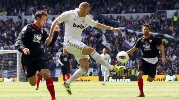 Real Madrid&#039;s Karim Benzema (C) fights for the ball with Sevilla FC&#039;s Ivan Rakitic (L) during their Spanish first division soccer match at Santiago Bernabeu stadium in Madrid April 29, 2012