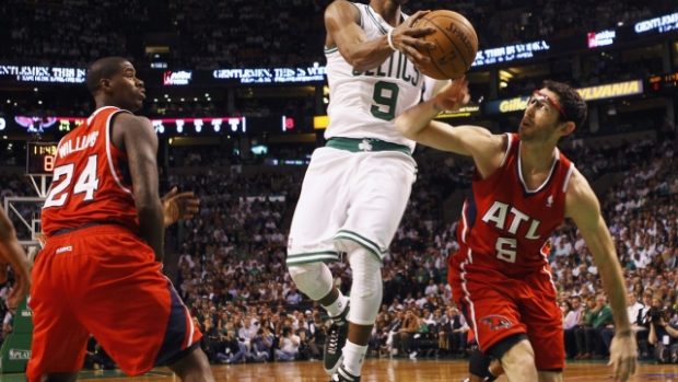 Boston Celtics guard Rajon Rondo  (C) drives to the basket between Atlanta Hawks forward Marvin Williams (L) and guard Kirk Hinrich during the first quarter of Game 3 of their NBA Eastern Conference playoff basketball series