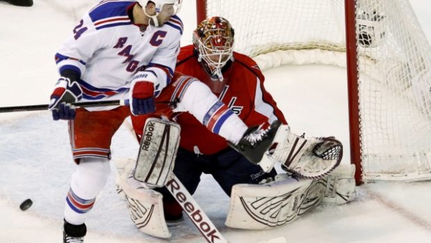 New York Rangers&#039; Ryan Callahan leaps in the air in front of Washington Capitals goaltender Braden Holtby during first period of game six of their NHL Easter Conference hockey semi-final game in Washington May 9, 2012
