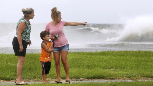 Lidé pozorují vlny narážející na břehy jezera Pontchartrain. Tropická bouře Isaac směřuje na New Orleans v Louisianě