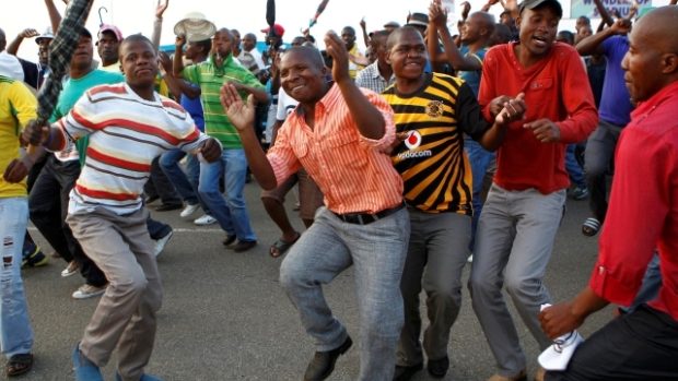 Stávkující horníci z dolu Marikana oslavují tancem zprávu o zvýšení platů