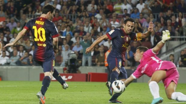 Barcelona&#039;s Xavi Hernandez (C) fights for the ball against Granada&#039;s goalkeeper Tono Martinez (R) after a Lionel Messi (L) shot during their Spanish First Division soccer league match at Camp Nou stadium in Barcelona  September 22, 2012