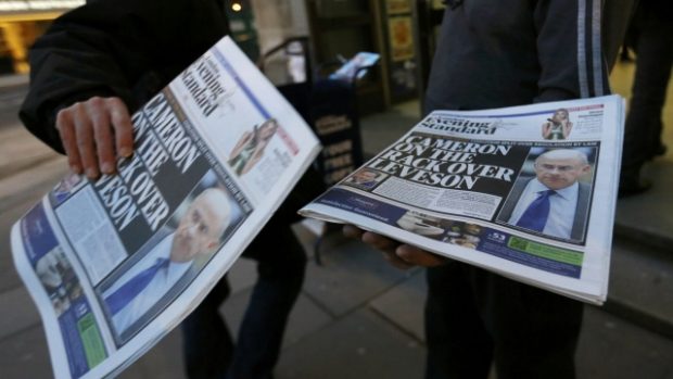 A man takes a copy of an evening newspaper, which features an article about Lord Justice Brian Leveson&#039;s report on media practices on its front page, in central London November 29, 2012