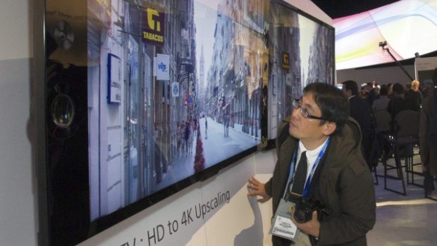 Novinář si prohlíží 4K televizi na veletrhu CES v Las Vegas.