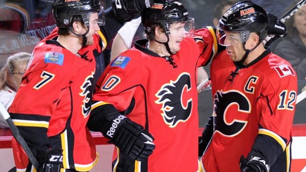 Hokejista Roman Červenka (uprostřed) přijímá gratulace od svých spoluhráčů z Calgary po svém druhém gólu v duelu proti St.Louis