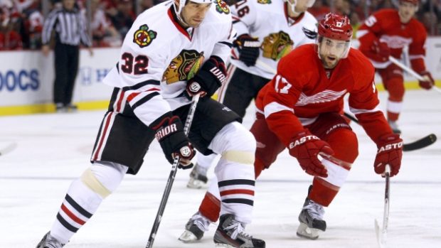 Michal Rozsíval (vlevo v bílém) v utkání Chicaga s Detroitem v NHL