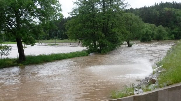 Rozlitá Klabava v Nové Huti na Plzeňsku. Na snímku vpravo je loni dokončený protipovodňový val, který odděluje řeku od obydlené části