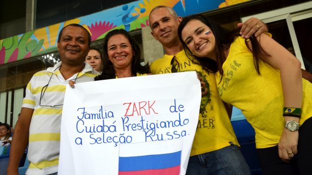 Brazílie, MS ve fotbale, zápas Rusko - Jižní Korea. Rodina Zark podporuje ruskou reprezentaci, stojí na plakátu ženy, která přes mistrovství hledá své předky