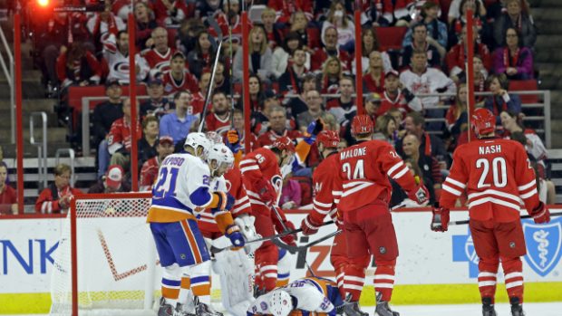 Brock Nelson leží před brankou Hurricanes po bolestivé teči, kterou zvyšoval na 2:0