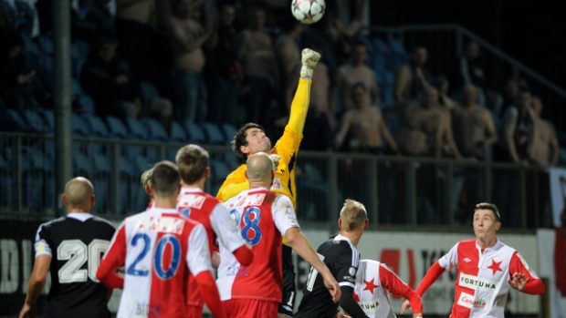 Brankář Slavie Hrubeš vyráží míč před dotírajícími hráči Českých Budějovic