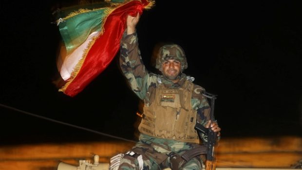 Bojovník kurdských milic pešmerga na vojenském voze mířícím do Kobani