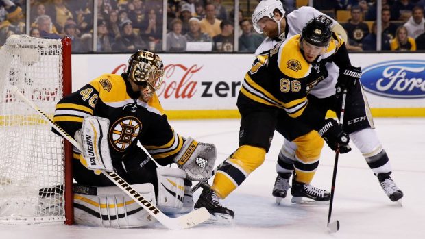 Bostonský brankář Tuukka Rask při zákroku proti dorážejícímu Philu Kesselovi v nočním zápase NHL