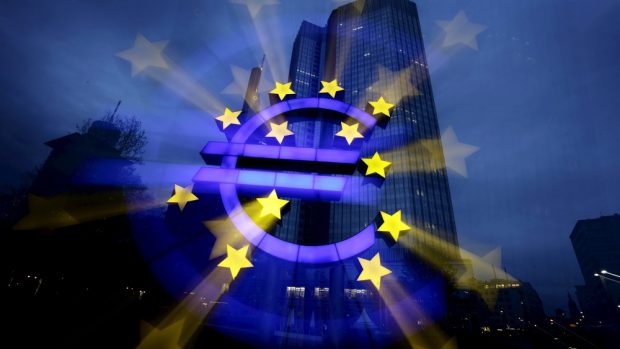 Symbol eura, v pozadí sídlo ECB ve Frankfurtu (ilustrační foto)