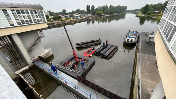 Jezové pole je nejdříve potřeba odvodnit. K tomu slouží stěna, kterou plovoucí jeřáb právě instaluje