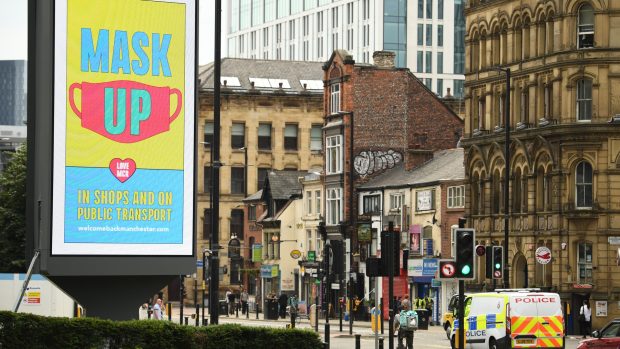 Billboard v anglickém Manchesteru, který upozorňuje na nošení roušek
