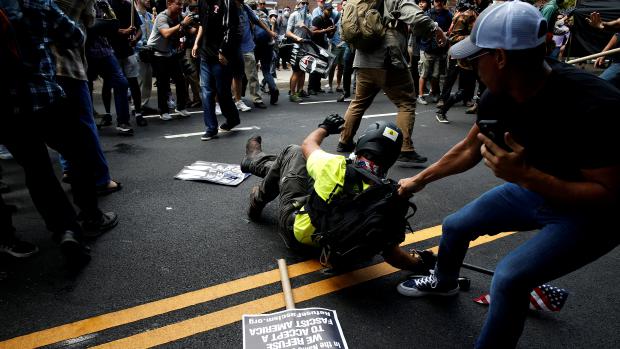 Muž se snaží odtáhnout pravicového extremistu pryč od demonstrantů