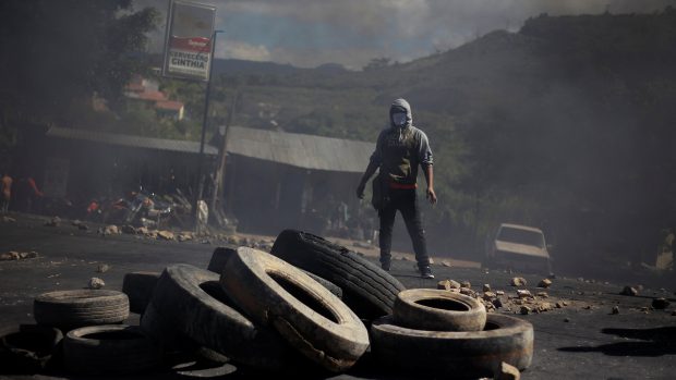 Protestující v honduraském hlavním městě Tegucigalpa u hromady pneumatik