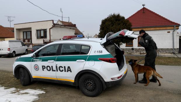 Policista se služebním psem před domem, kde Ján Kuciak a jeho snoubenka Martina Kušnírová žili a byli zavražděni (Veľká Mača, 27. února 2017).